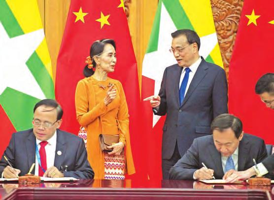Kyi (back, left) talks with Chinese Premier Li Keqiang (back, right) during a signing ceremony at the Great Hall of the People in Beijing yesterday.