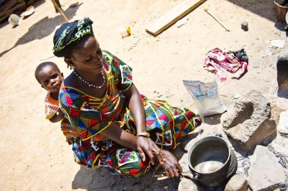 Burkina Faso: A mother receives a monthly ration of Super Cereal Plus, and takes it home to prepare it for her child.