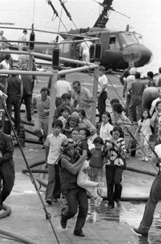AP U.S. Marine helicopter crewmen carry Vietnamese civilians to safety aboard the U.S.S. Blue Ridge on April 29, 1975. Their evacuation helicopter crashed on the deck of the amphibious command ship.