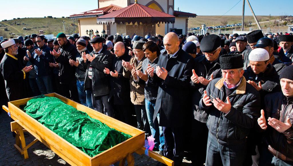 Human Rights on Occupied Territory: Case of Crimea Crimean Tatars bow their heads, praying over the body of Rishat Ametov, in the city of Simferopol, Crimea.