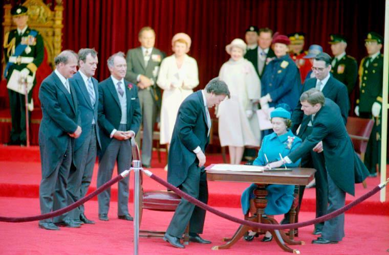 Her Majesty Queen Elizabeth II, Queen of Canada, signs the proclamation of the Canada Act (1982) and the Charter of Rights and Freedoms.