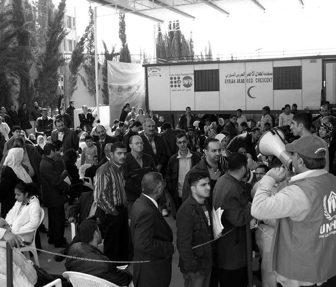 Fleeing Iraqis line up to register at the Duma