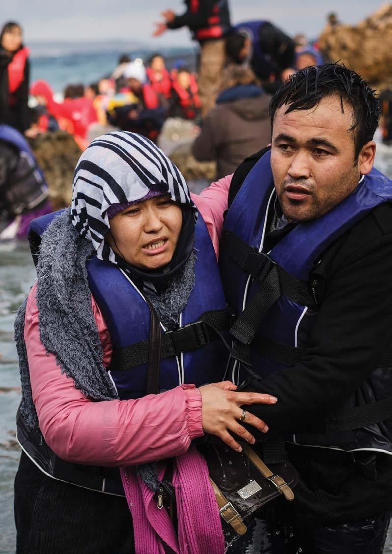 UNHCR / Achilleas Zavallis A refugee from Afghanistan helps his wife after the inflatable boat they used to cross the Aegean sea from the coast of Turkey