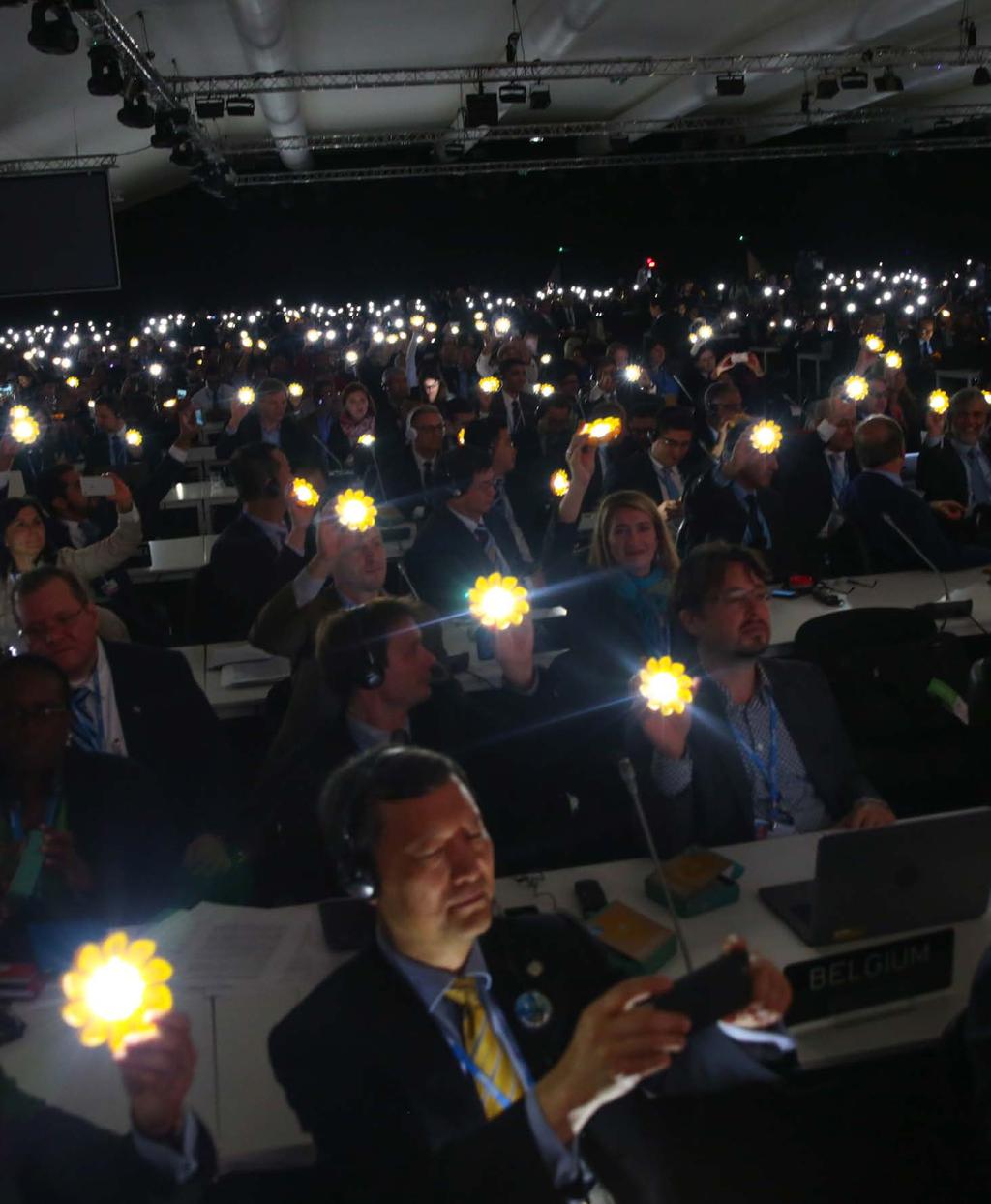 Delegates shine solar lights as a symbol of the transition to clean technology which is