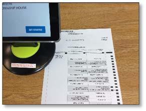 Place the ballot upside down on the check in table to the right of the ipad. Move the ballot slightly to scan the barcode.