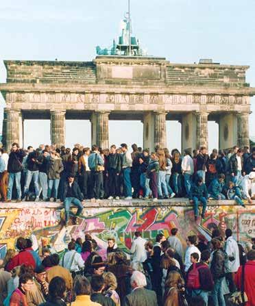 Communism Germans from East and West stand on the Berlin Wall in front of the Brandenburg Gate in this November 10, 1989 photo, one day after the wall