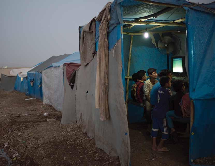 Children play video games in a makeshift arcade in the Arbat camp for internally displaced persons near Sulaymaniya, Iraq in June 2015. The Arbat IDP camp is one of the most overcrowded in Iraq.