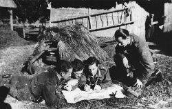 Army. Officers studying a map in a backyard of a cottage. From left to right: 2nd Lt.