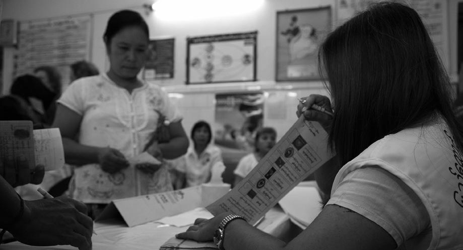 A polling officer gives a voter her ballot at a polling station in Yangon.