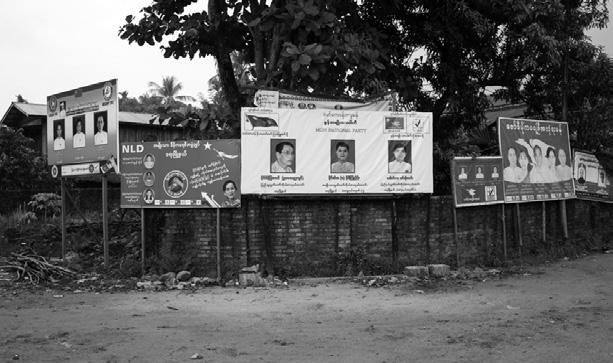 Political party campaign signs are displayed near a local market in Ye township, Mon state.