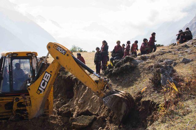 Picture 1: Picture shows a common scenario for rural development in Nepal. Children watching an excavator for their first time construction a road.