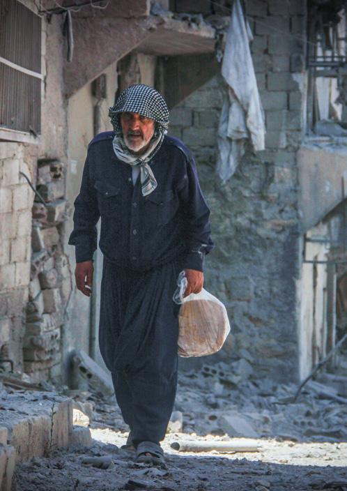 A man returns to his home in the city of Aleppo