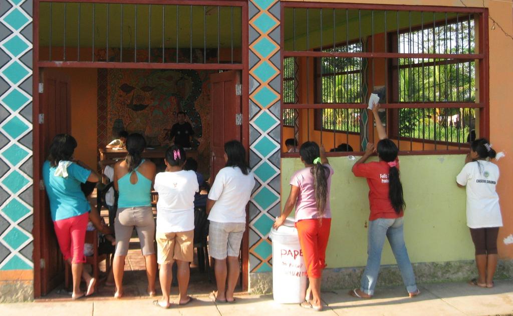 by non-governmental organizations seeking to support communities in their native land administration processes. Image 6. Cacataibo women stand outside their community s hall during a General Assembly.