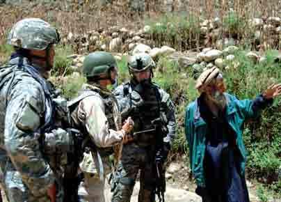 soldiers talk to a local Afghani farmer through an interpreter while on patrol in the Nuristan Province of Afghanistan.