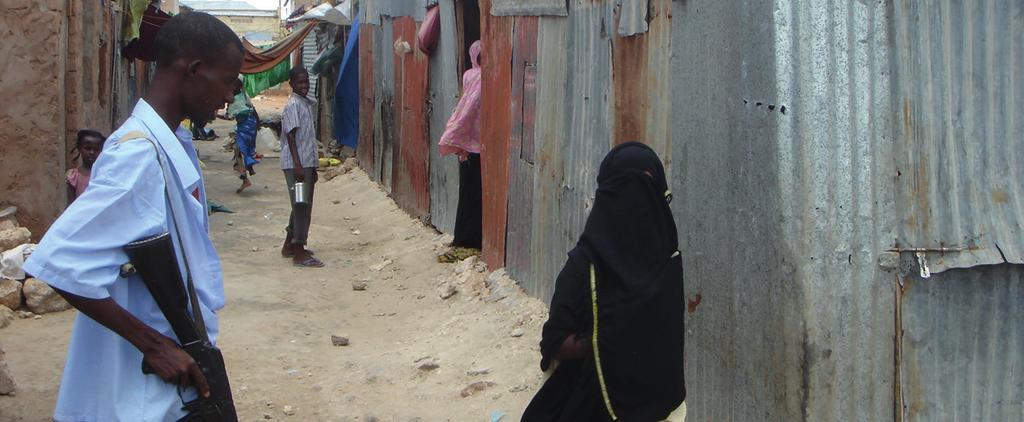 Woman passes an armed guard in Somalia. Photo: EC/ECHO/Phillipe Royan (CC BY-SA 2.
