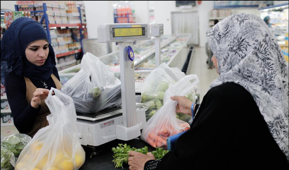 Syria refugee card 30 Halin Hussein, a mother of five, buys fruit in a supermarket in southern Lebanon that she will pay for using $150 coupons provided by Oxfam.