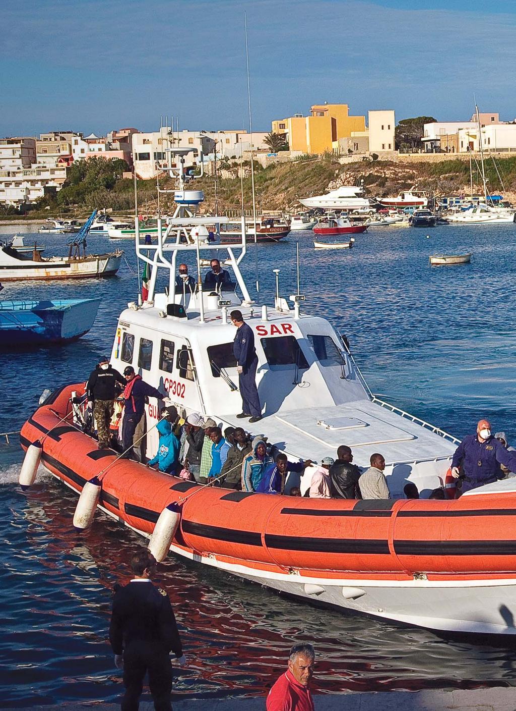 In Lampedusa s harbour, Italy, a patrol boat returns with asylum-seekers from a