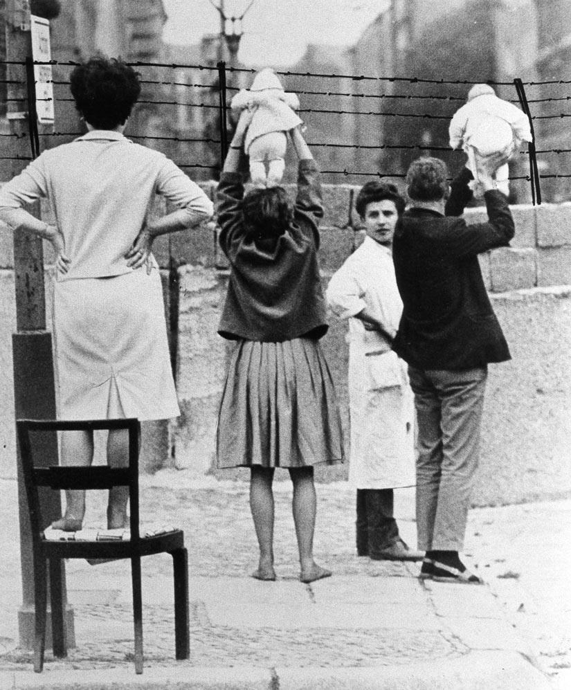 P L A C A R D M The End of the Cold War In this image from 1961, a family tries to visit with relatives who they have