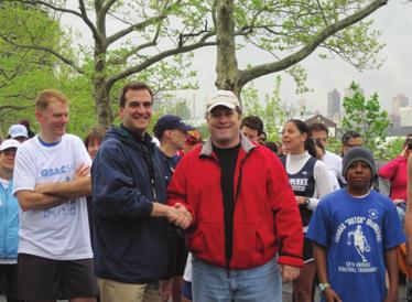 Assemblyman Michael Gianaris and other volunteers pass cups of water to 5k participants.