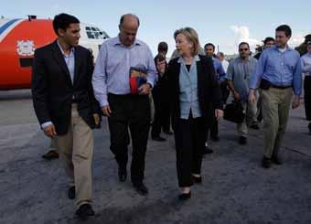U.S. Secretary of State Hillary Clinton and USAID Administrator Rajiv Shaw talk with U.S. Ambassador to Haiti Kenneth Merten ahead of a meeting with aid workers and Haiti s President Rene Preval in Port-au- Prince, Haiti, on Jan.