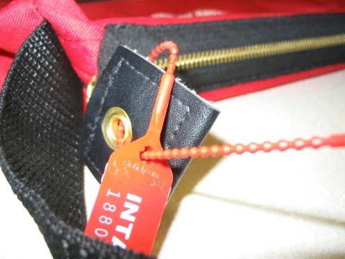 Lock the red bag and seal the other end with a red tie seal found in the
