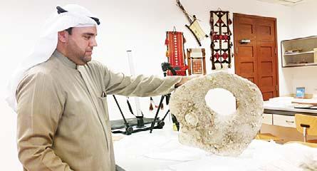 Center: Dr Ashkanani shows the barnacles on the inside of a fragment of a large ancient urn found off the coast of Kuwait by a fi sherman and donated to the museum.