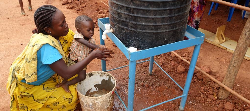 Catherina and her son Sabri, 10 months, wash their hands with clean water and soap at the UNICEF-supported Outpatient Therapeutic Programme in the Wau Protection of Civilians site.