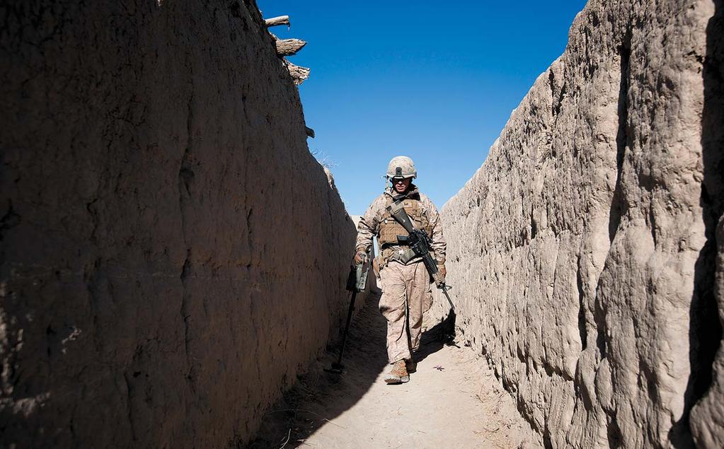 (U.S. Marines, Cpl Reece Lodder) U.S. Marine Cpl Cameron Collier, 3d Battalion, 3d Marine Regiment, sweeps an alleyway with a mine detector during a security patrol, Banadar, Helmand Province, Afghanistan, 6 February 2012.