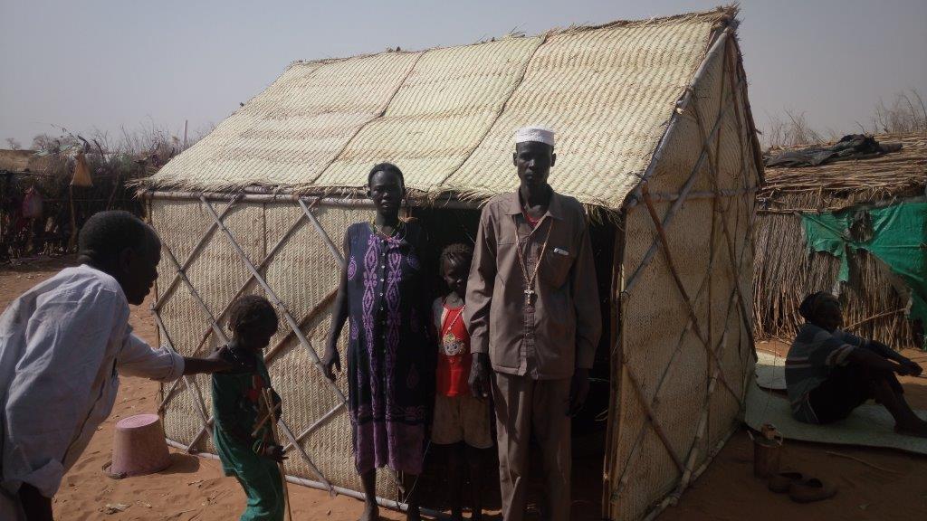 A refugee family in Al Lait stand beside their newly-constructed shelter, following UNHCR s distribution of shelter materials to over 2,000 refugee families. Photo credit: UNHCR, February 2018.