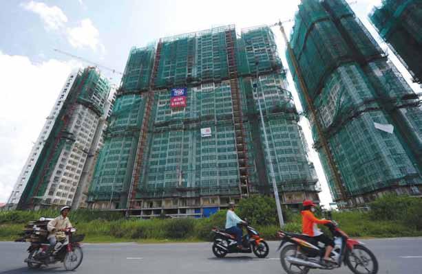 property December 10-16, 2012 28 the MyanMar times Motorcyclists ride past a residential towers construction site in the suburbs of Ho Chi Minh City on August 8, 2011.