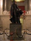 Cast Bronze statue of Abraham Lincoln standing beside a chair located in the center of the Rotunda. Statue is 14'-0" high. Base is of serpentine marble from Easton, Pennsylvania.