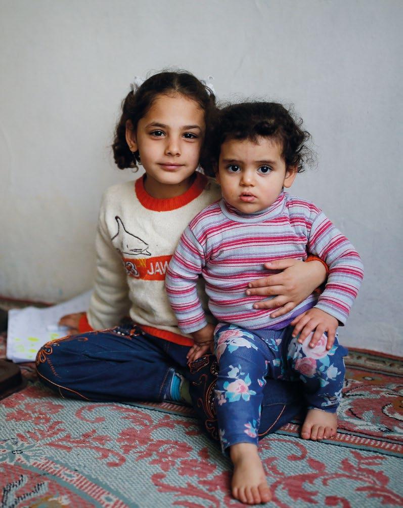 Chapter 2 Turkey. Seven-year-old Vahide holds her baby sister, Busra, in their private accommodation in Istanbul.