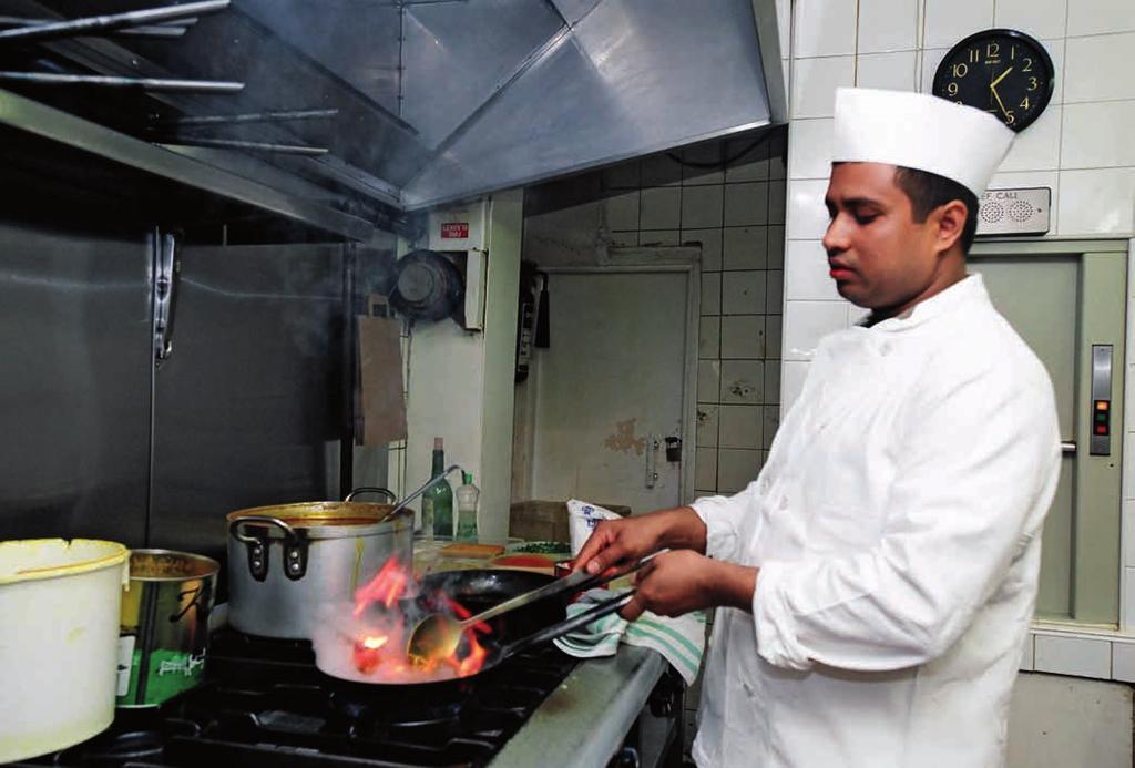 Migrant populations are amongst the groups affected by undeclared work in the European Union. A chef in a restaurant, London, UK.