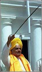 Former Indian Prime Minister, Atal Bihari Vajpayee, displays a sword given to
