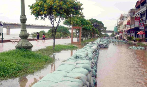 busily pile sand bags to prevent from further inundation amid heavy torrential monsoon