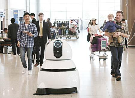Heads swiveled and children approached with curiosity as the 140-cm (4 foot 6 inch) robot with its white body and black screens glided through the terminal.