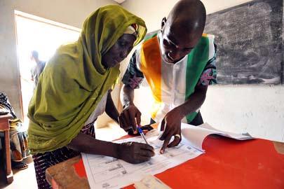 A woman signs a document certifying her vote in Côte d Ivoire s legislative elections, at a polling station in Bondoukou in 2011.