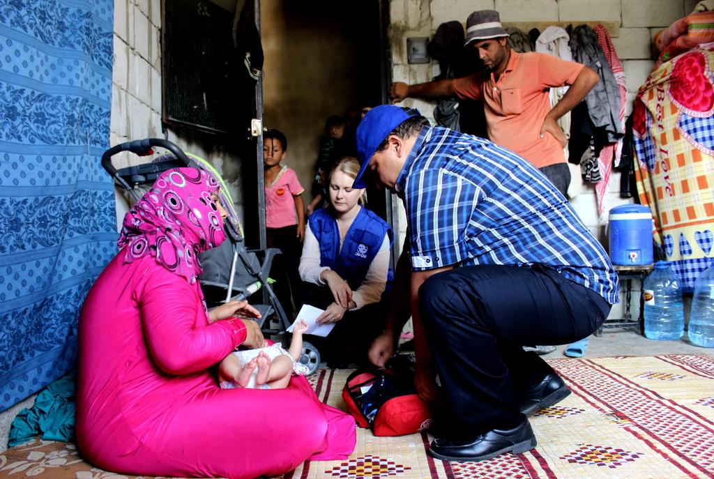 LEBANON OPERATIONS cont. A doctor examines an infant with a heat rash at a collective centre in Sarafand.