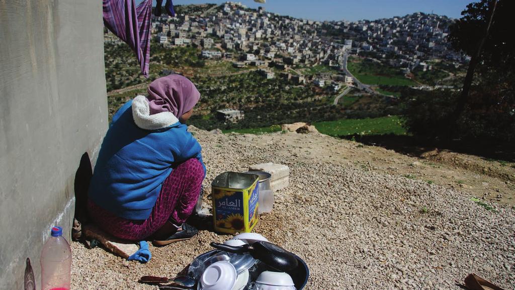 Noor, 17, washing the dishes outside her home in Irbid, Jordan.