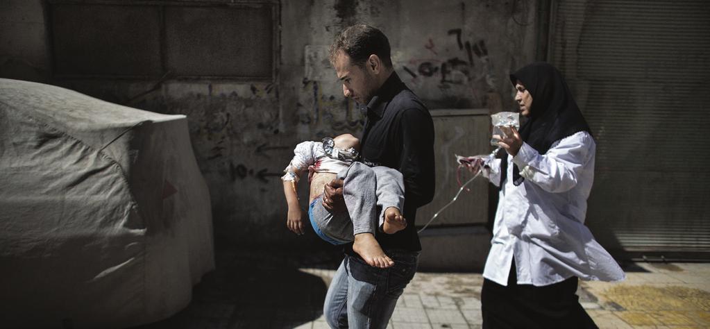 PHRecord Summer 2014 3 4 6 7 8 A Syrian man carries his wounded daughter outside a hospital in the northern city of Aleppo.