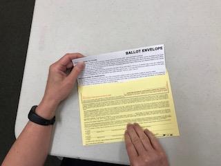 Place the marked ballot into the white ballot envelope (also known as the
