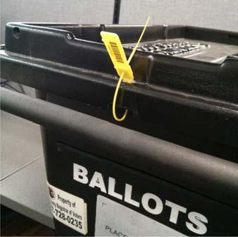 B To complete locking of the Ballot Box, do the following: (i) Loop narrow end of strap through hole in the flat end of lock.