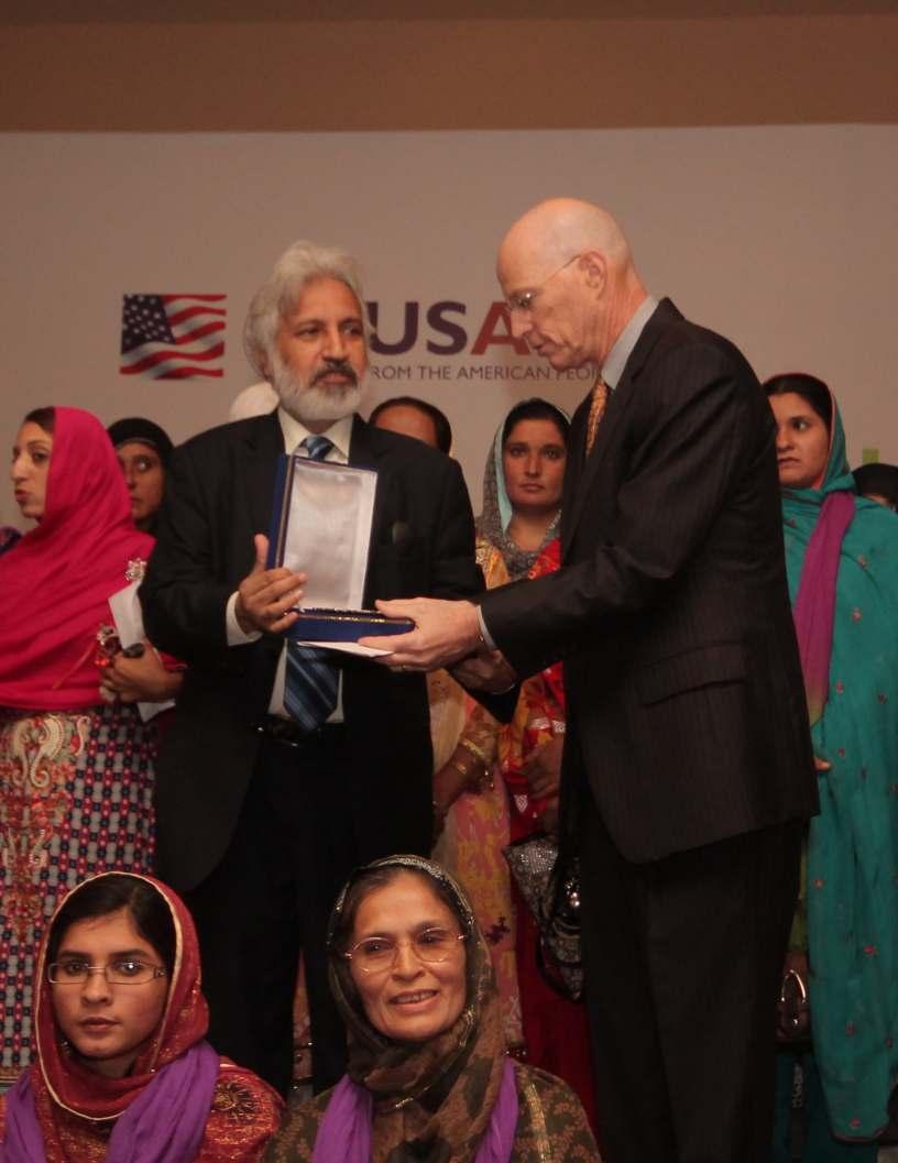 Chief Operating Officer, Aurat Foundation, Naeem Mirza presents memento to USAID's
