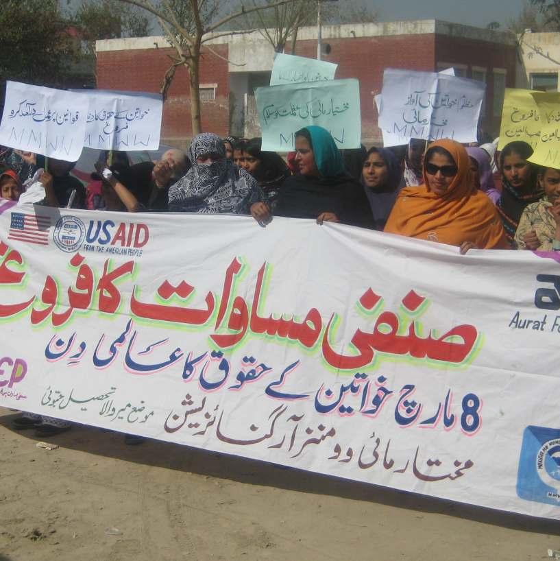 Participants hold banners and placards during a rally organized by Mukhtar Mai