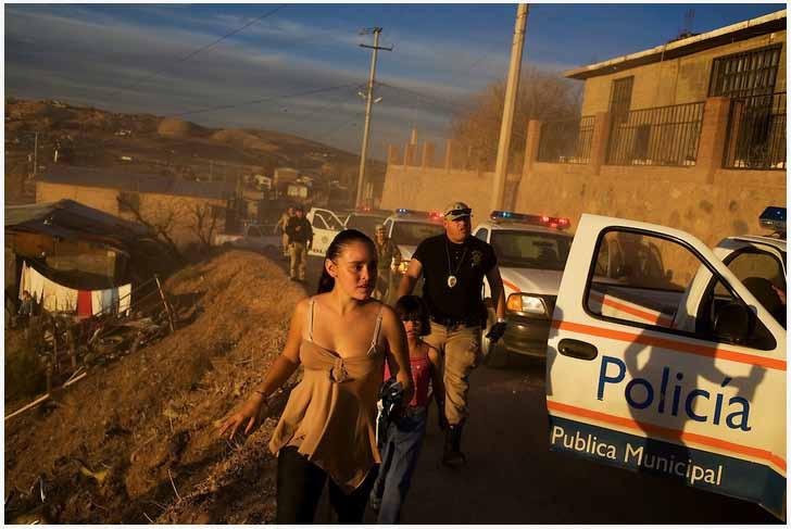 David Rochkind A young girl walks by a caravan of police vehicles during a security sweep looking for criminals and drug dealers in Nogales, Sonora.