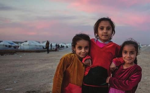UNHCR/Rasheed Hussein Rasheed Three friends smile for the camera as