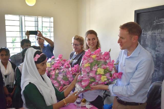 UNHCR Controller Hans Baritt (first from right), and Senior Operations Manager Elisabeth Pelster (third from right) receive flowers from Leda High School students during the inauguration of the newly