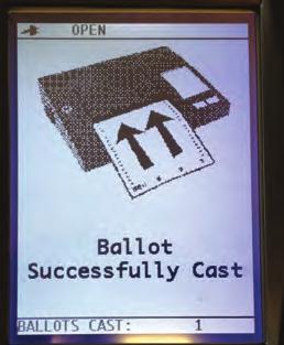 The scanner will draw the ballot from the sleeve. 3.