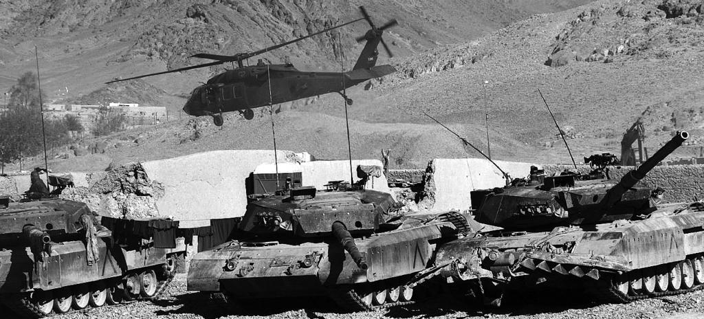 NATO tanks and helicopters in Afghanistan. Photo: Yves Gemus When humanitarian actions are coordinated with state actions or protected by combat troops, Are agencies any longer independent or neutral?