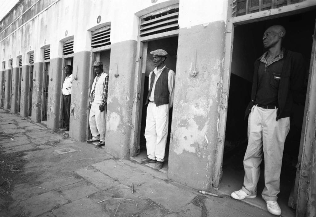 Ex-prisoners in the doorways of their former cells at Constitution Hill. Photograph by Oscar G.
